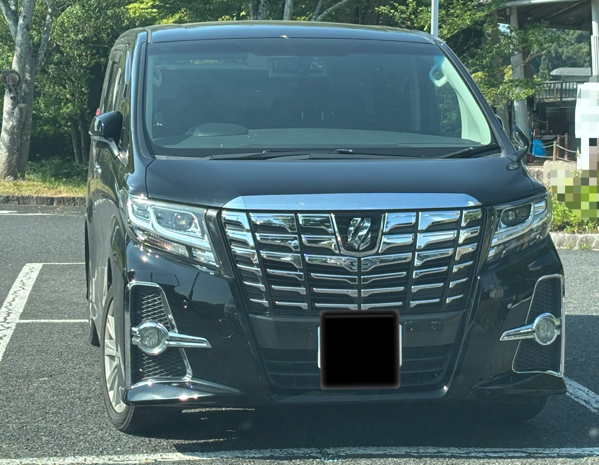 駐車場に停車している黒い30系後期アルファードのフロントデザイン