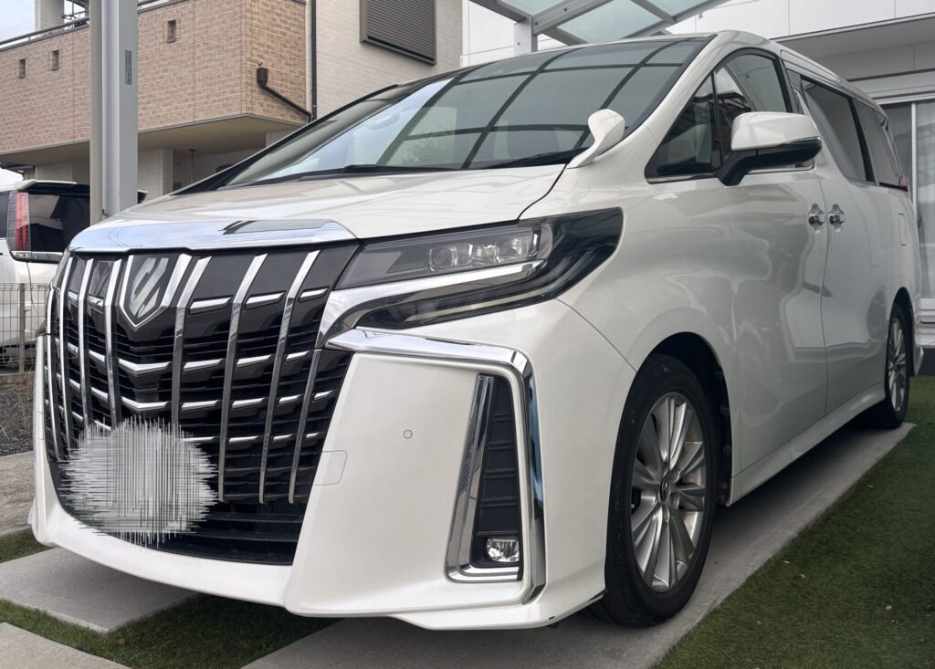 カーポートに駐車した白い30系後期アルファードのフロントグリルとヘッドライト