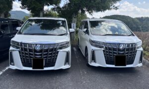 駐車場に並ぶ白い30系後期アルファード2台のフロントデザイン比較