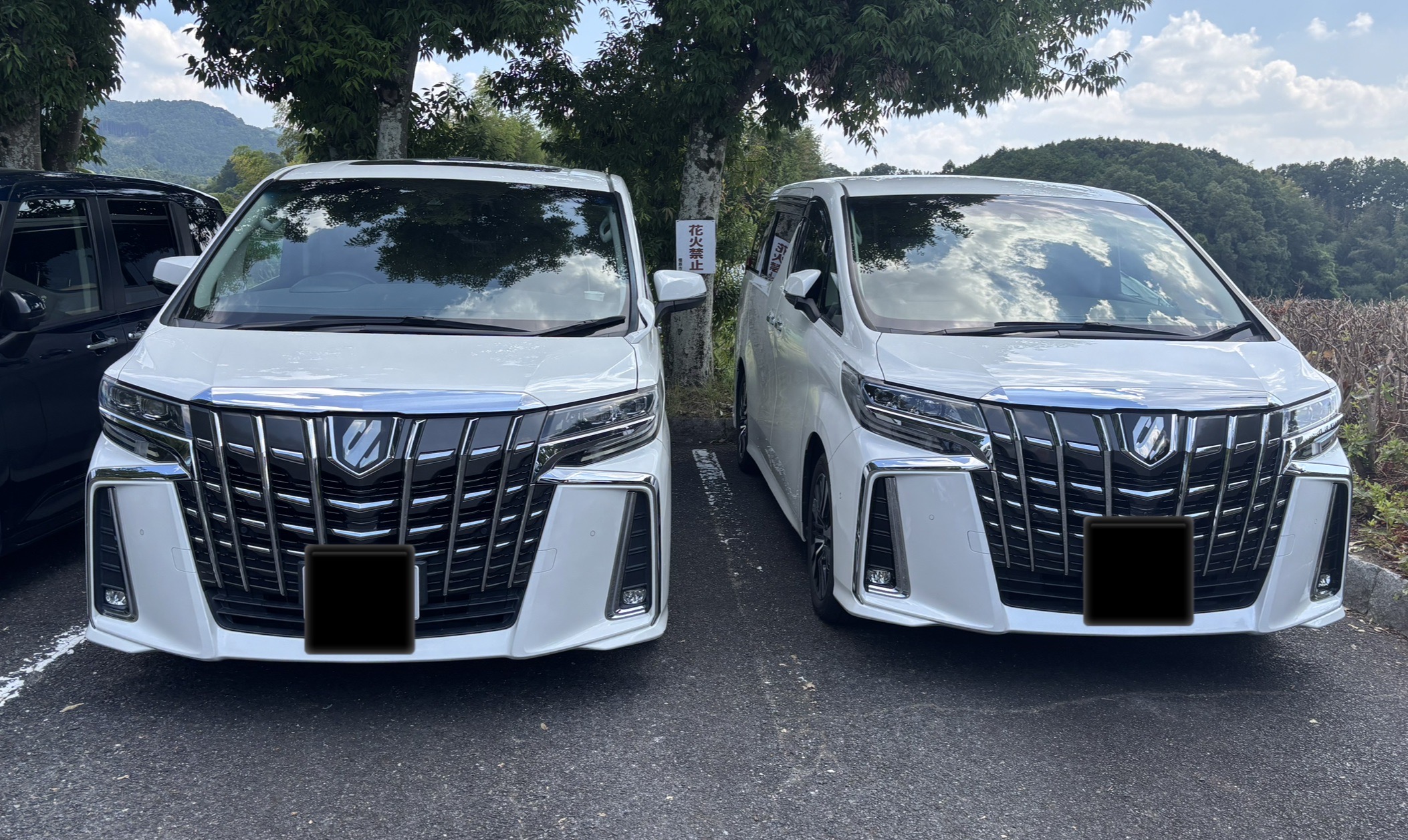 駐車場に並ぶ白い30系後期アルファード2台のフロントデザイン比較