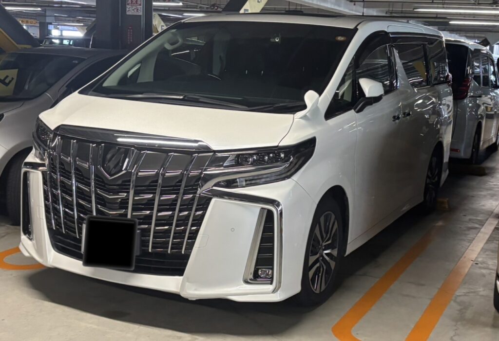 立体駐車場に停車している白い30系後期アルファードを左前方から撮影